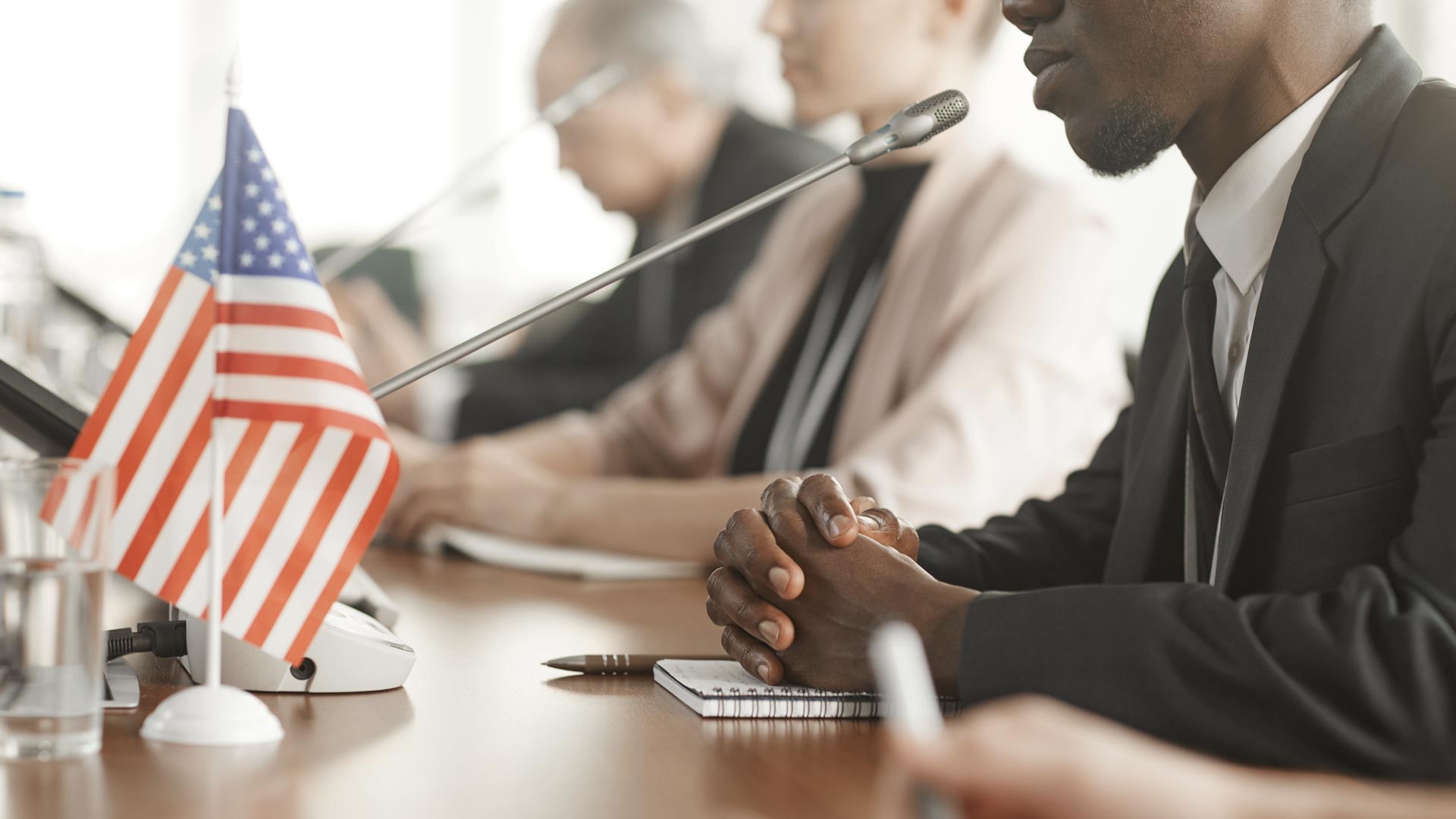 Man presenting at a meeting with an American flag on the table