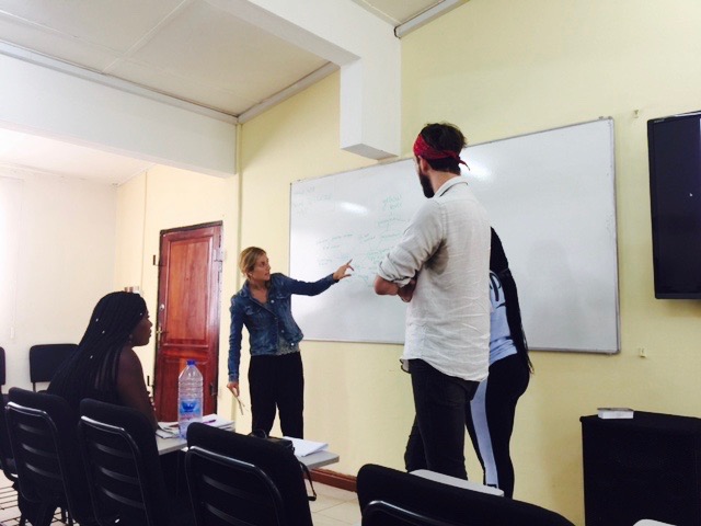 Photo: Fabiana, Ashyln, and Joel giving their presentation in class at NYU Accra.