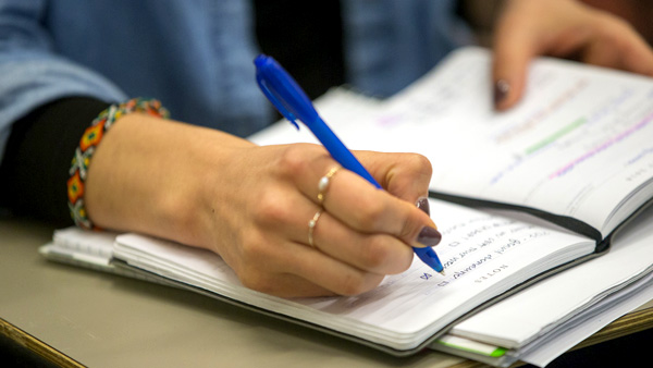 Student writing in notebook