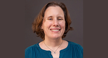 Headshot of Professor Christiana Coyle with dark gray background