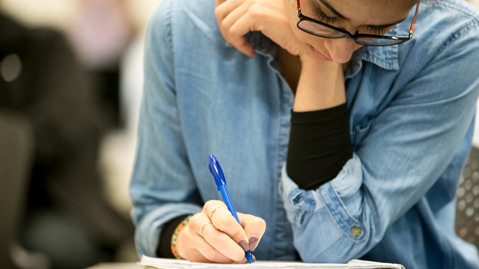 Student filling out paperwork at a desk