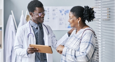 Black doctor speaking with patient