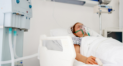 patient with an oxygen mask lying down in bed