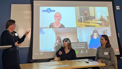 Presenters pointing at a projection screen with zoom panelists