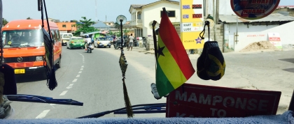 View from local TroTro transport van, packed with people, including a minister delivering his sermon.