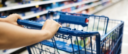 Person pushing shopping cart in a grocery store