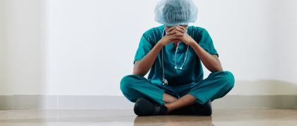 Stressed nurse sitting on the floor